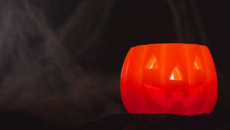 Halloween-Pumpkin-Jack-O-Lantern-With-Candle-Against-Black-Background-With-Cobwebs-2