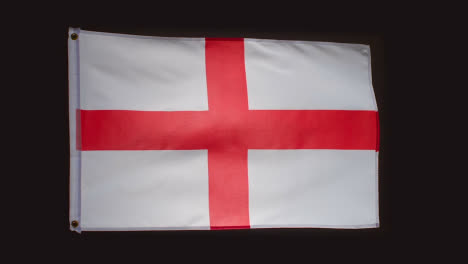 Studio-Shot-Of-Saint-George-Flag-Of-England-Flying-Against-Black-Background