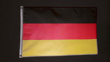 Studioaufnahme-Der-Flagge-Deutschlands,-Die-Vor-Schwarzem-Hintergrund-Fliegt