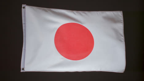 Foto-De-Estudio-De-La-Bandera-De-Japón-Volando-Sobre-Fondo-Negro-1