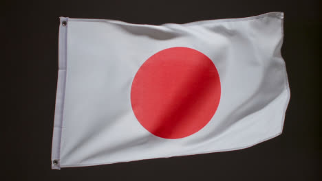 Foto-De-Estudio-De-La-Bandera-De-Japón-Volando-Sobre-Fondo-Negro-1