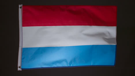 Studioaufnahme-Der-Flagge-Der-Niederlande,-Die-Vor-Schwarzem-Hintergrund-Fliegt