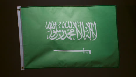Studio-Shot-Of-Flag-Of-Saudi-Arabia-Flying-Against-Black-Background
