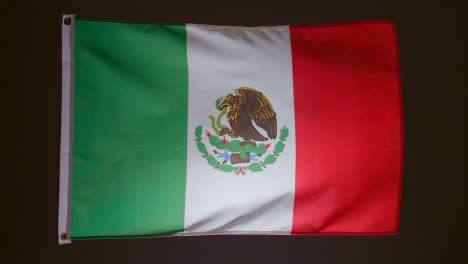 Foto-De-Estudio-De-La-Bandera-De-México-Volando-Contra-Fondo-Negro