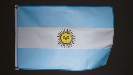 Foto-De-Estudio-De-La-Bandera-Argentina-Contra-El-Fondo-Negro