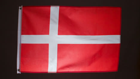 Studioaufnahme-Der-Dänischen-Flagge-Vor-Schwarzem-Hintergrund