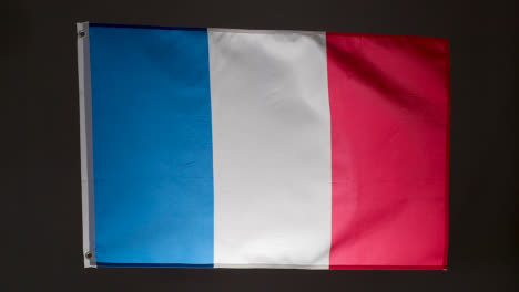 Studio-Shot-Of-Flag-Of-France-Flying-Against-Black-Background