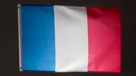 Studioaufnahme-Der-Flagge-Frankreichs,-Die-Vor-Schwarzem-Hintergrund-Herunterfällt