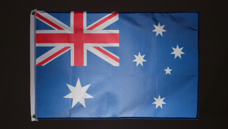 Studioaufnahme-Der-Neuseeländischen-Flagge,-Die-Vor-Schwarzem-Hintergrund-Herunterfällt