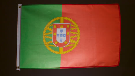 Studioaufnahme-Der-Portugiesischen-Flagge,-Die-Vor-Schwarzem-Hintergrund-Herunterfällt