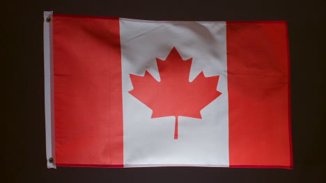 Studioaufnahme-Der-Flagge-Kanadas-Vor-Schwarzem-Hintergrund