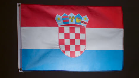 Studio-Shot-Of-Flag-Of-Croatia-Flying-Against-Black-Background