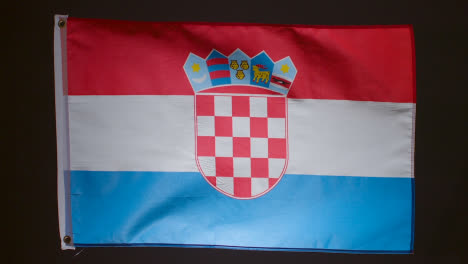 Studioaufnahme-Der-Flagge-Kroatiens,-Die-Vor-Schwarzem-Hintergrund-Herunterfällt