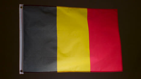 Studioaufnahme-Der-Belgischen-Flagge-Vor-Schwarzem-Hintergrund
