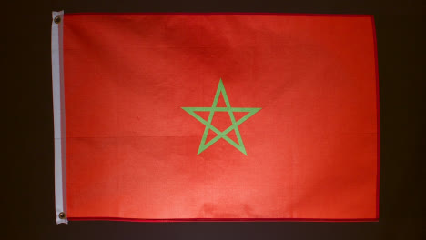 Studioaufnahme-Der-Marokkanischen-Flagge,-Die-Vor-Schwarzem-Hintergrund-Herunterfällt