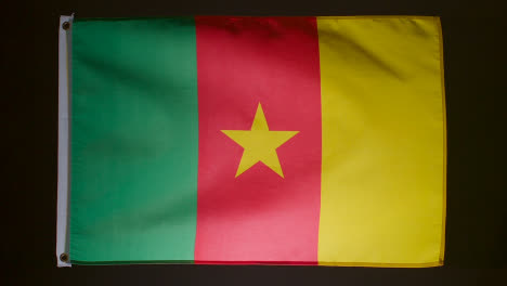 Studioaufnahme-Der-Flagge-Kameruns,-Die-Vor-Schwarzem-Hintergrund-Herunterfällt