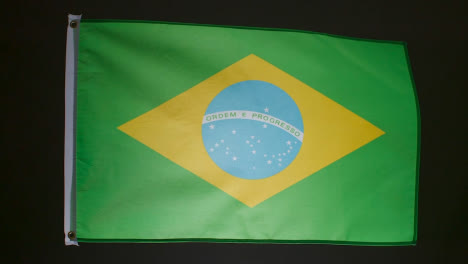 Studioaufnahme-Der-Brasilianischen-Flagge-Vor-Schwarzem-Hintergrund