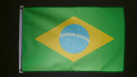 Studioaufnahme-Der-Brasilianischen-Flagge,-Die-Vor-Schwarzem-Hintergrund-Herunterfällt