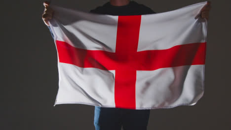 Studioaufnahme-Einer-Anonymen-Person-Oder-Eines-Sportfans,-Der-Die-Englische-Flagge-Von-Saint-George-Vor-Schwarzem-Hintergrund-Schwenkt