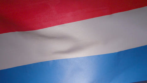 Cerrar-Foto-De-Estudio-De-La-Bandera-Holandesa-Que-Enarbola-Marco-De-Relleno