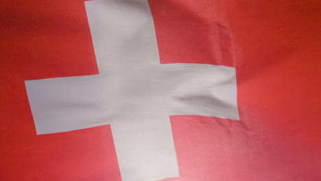 Close-Up-Studio-Shot-Of-Swiss-Flag-Flying-Filling-Frame