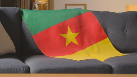 Flagge-Von-Kamerun-Zu-Hause-über-Sofa-Drapiert,-Fußball-Bereit-Für-Spiel-Im-Fernsehen-4