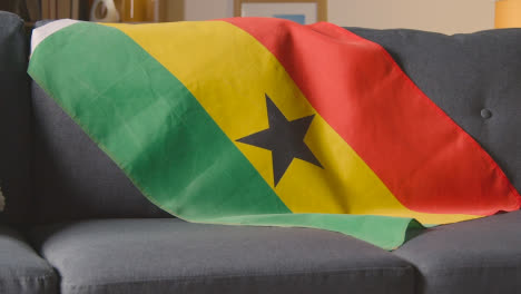 Bandera-De-Ghana-Sobre-Un-Sofá-En-Casa-Con-Fútbol-Listo-Para-El-Partido-En-La-Televisión