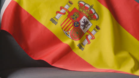 Nahaufnahme-Der-Flagge-Spaniens,-Die-Zu-Hause-über-Dem-Sofa-Drapiert-Ist,-Bereit-Für-Das-Spiel-Im-Fernsehen