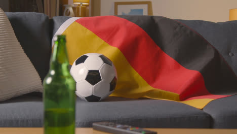 Flagge-Von-Deutschland-über-Sofa-Zu-Hause-Drapiert-Mit-Fußball-Bereit-Für-Spiel-Im-Fernsehen