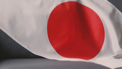 Nahaufnahme-Der-Flagge-Japans,-Die-Zu-Hause-über-Dem-Sofa-Drapiert-Ist,-Bereit-Für-Das-Spiel-Im-Fernsehen