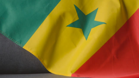 Nahaufnahme-Der-Flagge-Von-Senegal,-Die-Zu-Hause-über-Dem-Sofa-Drapiert-Ist,-Bereit-Für-Das-Spiel-Im-Fernsehen