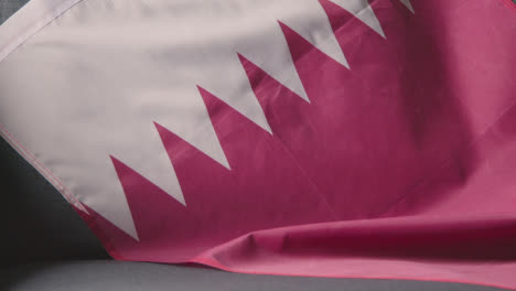 Nahaufnahme-Der-Flagge-Von-Katar,-Die-Zu-Hause-über-Dem-Sofa-Drapiert-Ist,-Bereit-Für-Das-Spiel-Im-Fernsehen