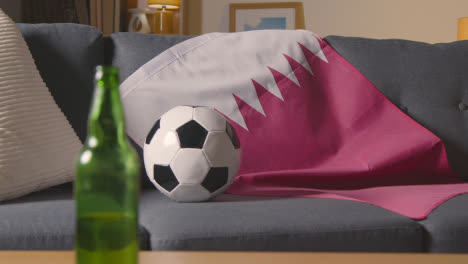 Bandera-De-Qatar-Sobre-Un-Sofá-En-Casa-Con-Fútbol-Listo-Para-El-Partido-En-Tv-1