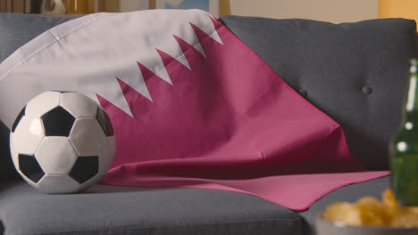 Bandera-De-Qatar-Sobre-Un-Sofá-En-Casa-Con-Fútbol-Listo-Para-El-Partido-En-Tv-2