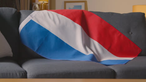 Flagge-Von-Holland-über-Dem-Sofa-Zu-Hause-Mit-Fußball-Bereit-Für-Das-Spiel-Im-Tv-3
