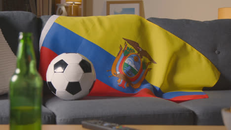 Flagge-Von-Ecuador-Zu-Hause-über-Sofa-Drapiert-Mit-Fußball-Bereit-Für-Das-Spiel-Im-Fernsehen
