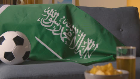 Flagge-Saudi-Arabiens-Zu-Hause-über-Dem-Sofa-Drapiert,-Bereit-Für-Das-Spiel-Im-Fernsehen-1