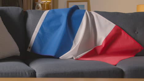 Flag-Of-France-Draped-Over-Sofa-At-Home-With-Football-Ready-For-Match-On-TV