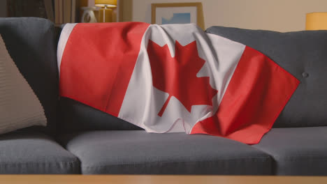 Flagge-Kanadas-Zu-Hause-über-Dem-Sofa-Drapiert,-Bereit-Für-Das-Spiel-Im-Fernsehen