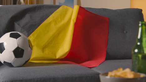 Flagge-Von-Belgien-über-Dem-Sofa-Zu-Hause-Mit-Fußball-Bereit-Für-Das-Spiel-Im-Tv-2