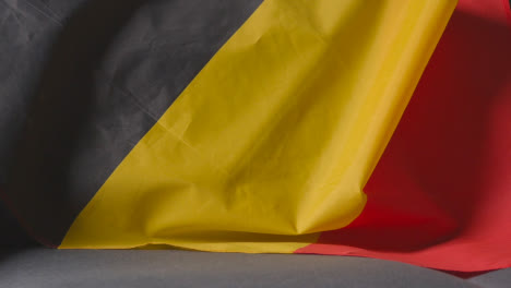 Close-Up-Of-Flag-Of-Belgium-Draped-Over-Sofa-At-Home-Ready-For-Match-On-TV