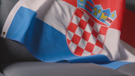 Nahaufnahme-Der-Flagge-Kroatiens,-Die-Zu-Hause-über-Dem-Sofa-Drapiert-Ist,-Bereit-Für-Das-Spiel-Im-Fernsehen