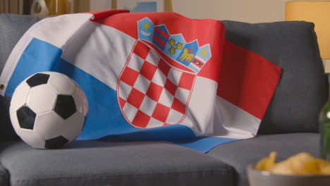 Flagge-Kroatiens-über-Sofa-Zu-Hause-Drapiert,-Fußball-Bereit-Für-Spiel-Im-Tv-1