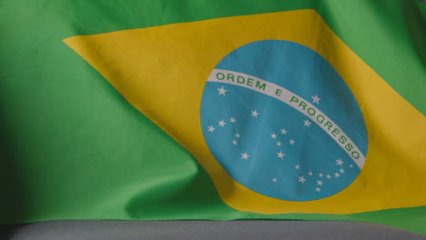 Nahaufnahme-Der-Flagge-Von-Brasilien,-Die-Zu-Hause-über-Dem-Sofa-Drapiert-Ist,-Bereit-Für-Das-Spiel-Im-Fernsehen