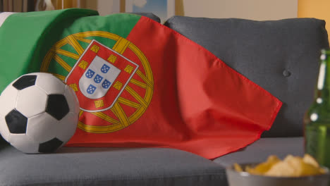 Flagge-Von-Portugal-über-Dem-Sofa-Zu-Hause-Mit-Fußball-Bereit-Für-Das-Spiel-Im-Tv-2