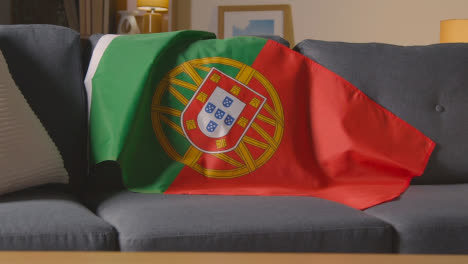 Flagge-Portugals-Zu-Hause-über-Dem-Sofa-Drapiert,-Bereit-Für-Das-Spiel-Im-Fernsehen