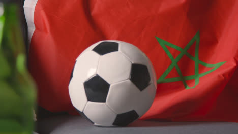 Bandera-De-Marruecos-Sobre-Un-Sofá-En-Casa-Con-Fútbol-Listo-Para-El-Partido-En-La-Televisión
