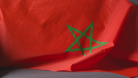 Nahaufnahme-Der-Marokkanischen-Flagge,-Die-Zu-Hause-über-Dem-Sofa-Drapiert-Ist,-Bereit-Für-Das-Spiel-Im-Fernsehen