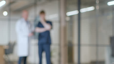 Defocused-Background-Shot-Of-Doctor-Working-In-Hospital-Meeting-With-Nurse-In-Scrubs