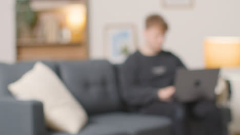 Defocused-Shot-Of-College-Student-Working-On-Laptop-At-Home-1